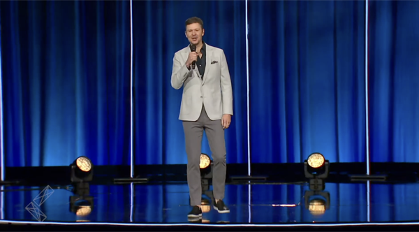 Tripp on stage in a tan suit