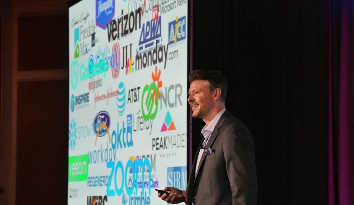 Tripp on stage with brand logos